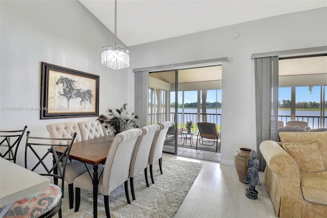 dining area featuring plenty of natural light, a water view, light wood-type flooring, and lofted ceiling