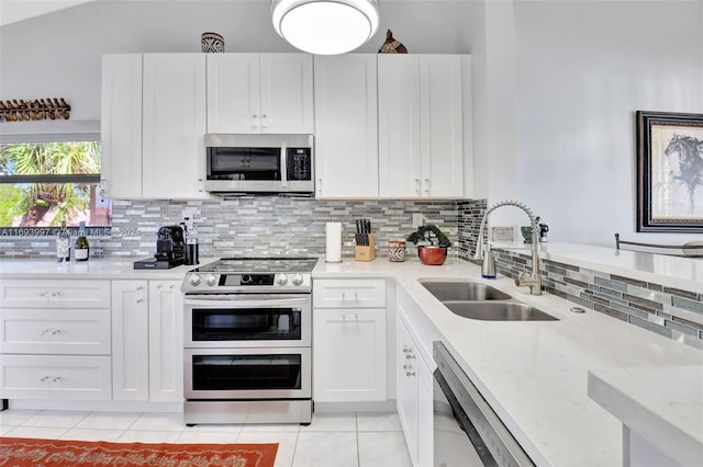 kitchen with sink, decorative backsplash, light tile patterned floors, white cabinetry, and stainless steel appliances