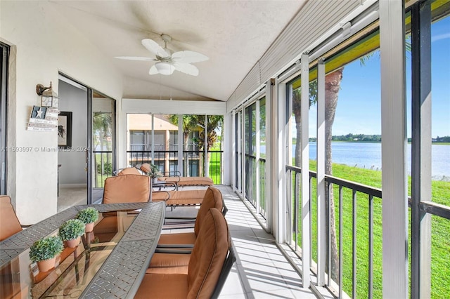 sunroom with ceiling fan, a water view, and vaulted ceiling