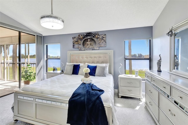 carpeted bedroom with a textured ceiling, access to outside, lofted ceiling, and a water view