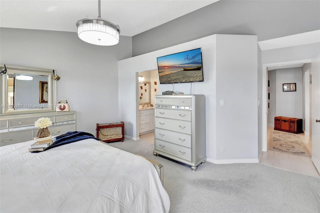 bedroom featuring light colored carpet and ensuite bathroom