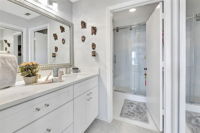 bathroom featuring tile patterned flooring, vanity, and an enclosed shower