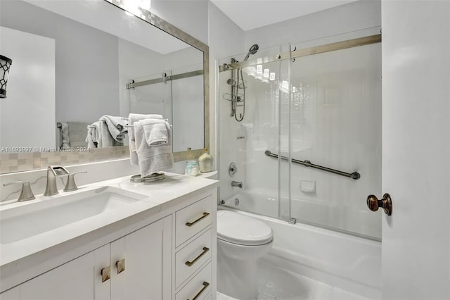 full bathroom featuring vanity, toilet, and shower / bath combination with glass door