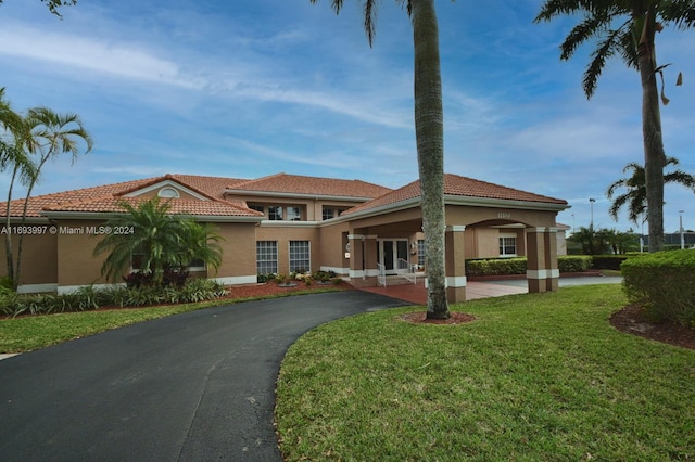 mediterranean / spanish home with a front lawn