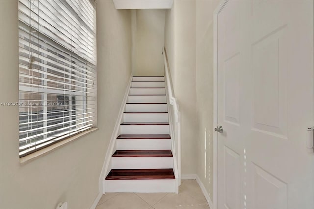 stairs with tile patterned floors and a healthy amount of sunlight