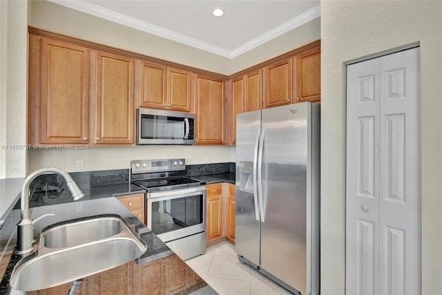 kitchen featuring sink, stainless steel appliances, dark stone counters, light tile patterned flooring, and ornamental molding