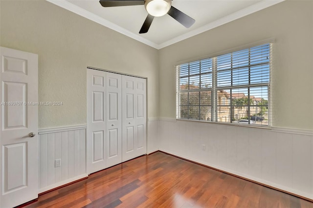 unfurnished bedroom featuring dark hardwood / wood-style flooring, a closet, ceiling fan, and ornamental molding