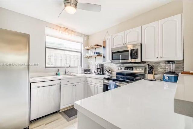 kitchen with white cabinetry, sink, stainless steel appliances, and light hardwood / wood-style floors