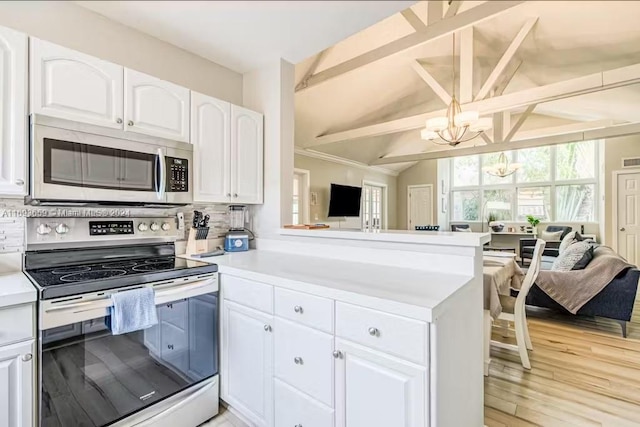 kitchen featuring white cabinets, appliances with stainless steel finishes, tasteful backsplash, and light hardwood / wood-style flooring