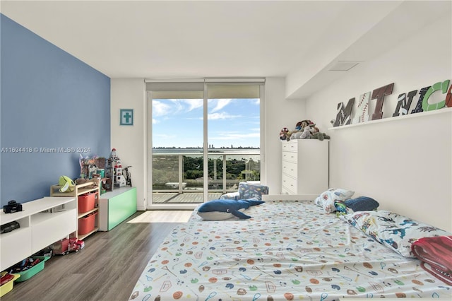 bedroom with hardwood / wood-style flooring and a wall of windows