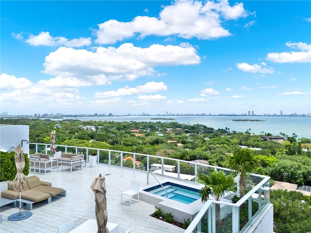 view of pool with an in ground hot tub, a water view, and an outdoor living space