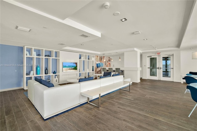 living room with a raised ceiling, dark hardwood / wood-style flooring, and french doors