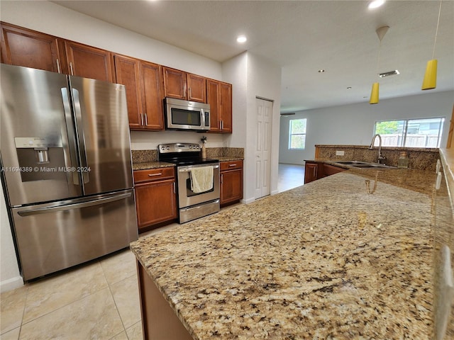 kitchen with light stone countertops, sink, and appliances with stainless steel finishes