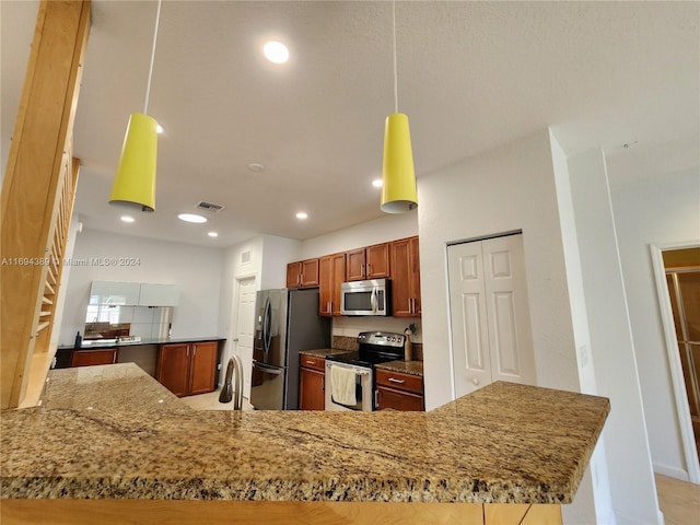 kitchen featuring decorative light fixtures, kitchen peninsula, sink, and appliances with stainless steel finishes