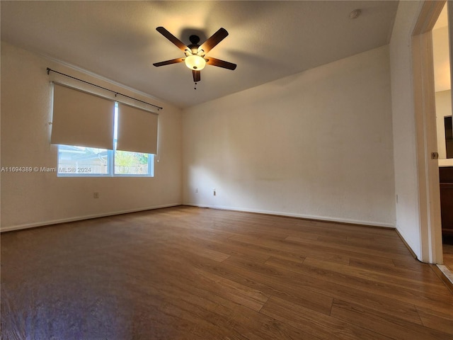 unfurnished room featuring ceiling fan and dark wood-type flooring