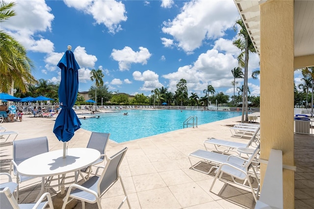 view of swimming pool with a patio and cooling unit