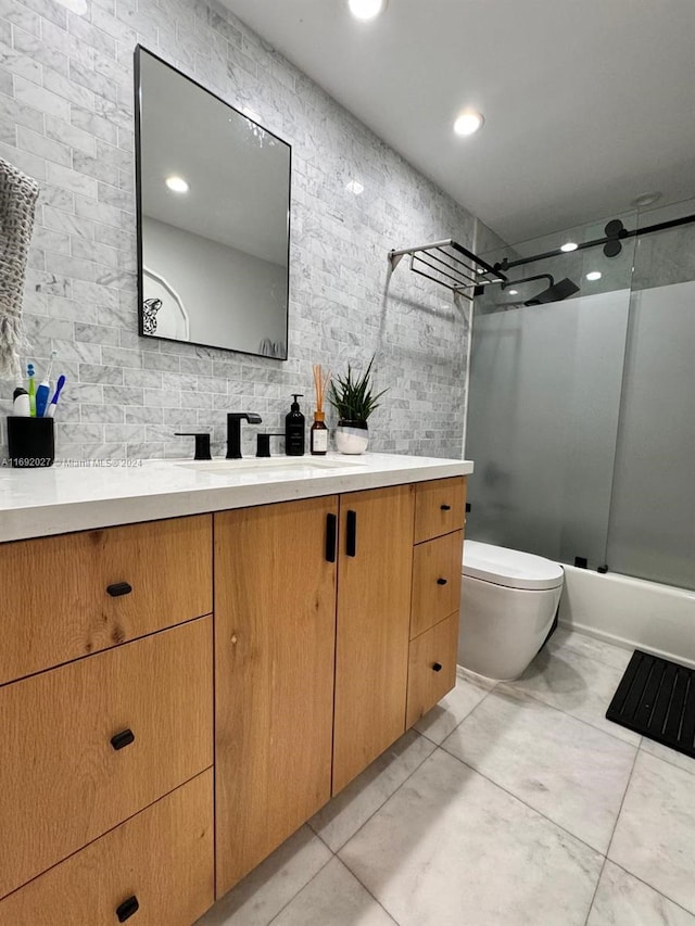 full bathroom with tile patterned flooring, vanity, toilet, and bath / shower combo with glass door