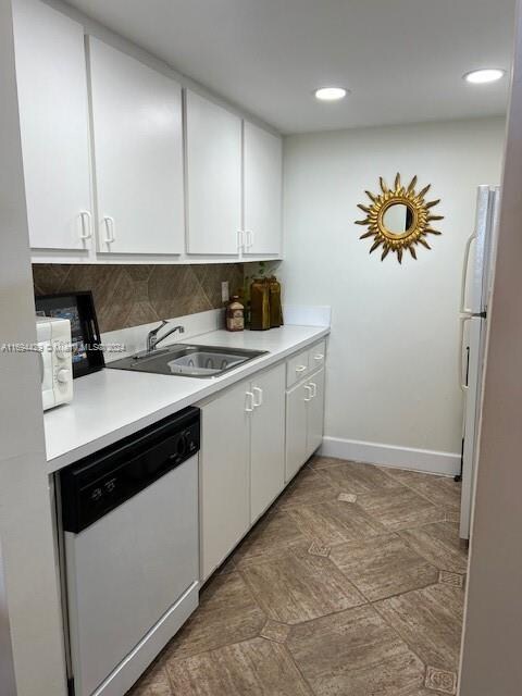 kitchen featuring white cabinets, decorative backsplash, white appliances, and sink