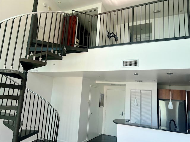 stairway featuring a towering ceiling