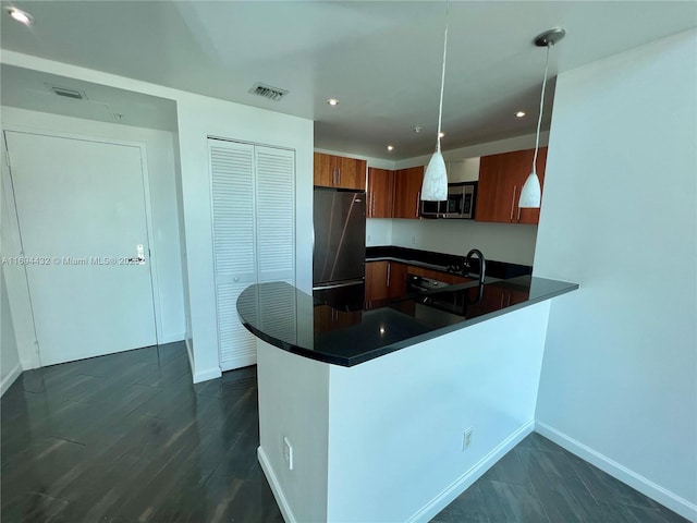 300 S Biscayne Blvd Unit 826, Miami, FL 33131 - kitchen featuring stainless steel appliances, dark countertops, brown cabinetry, a peninsula, and hanging light fixtures