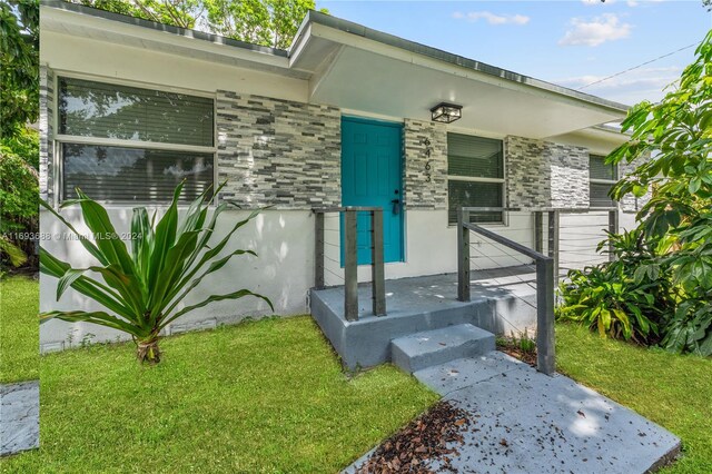 view of exterior entry with a lawn