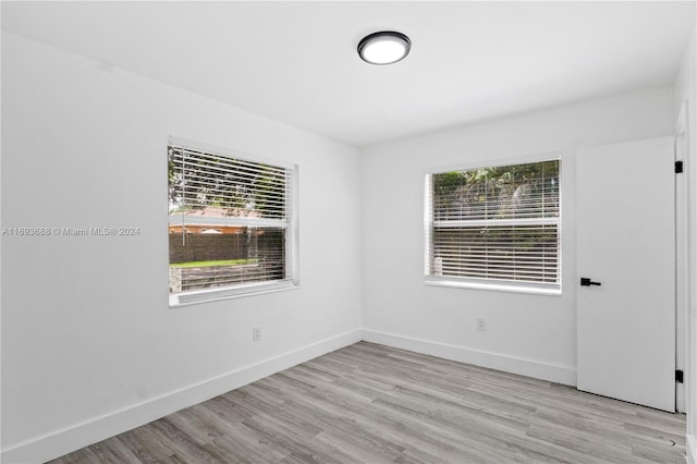 empty room with light wood-type flooring and a wealth of natural light