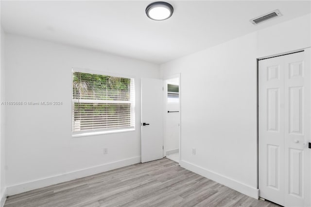 unfurnished bedroom featuring light hardwood / wood-style floors and a closet