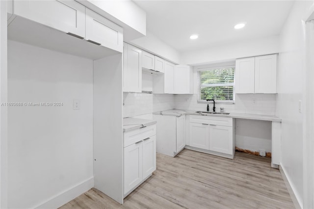 kitchen featuring light hardwood / wood-style floors, white cabinetry, and sink