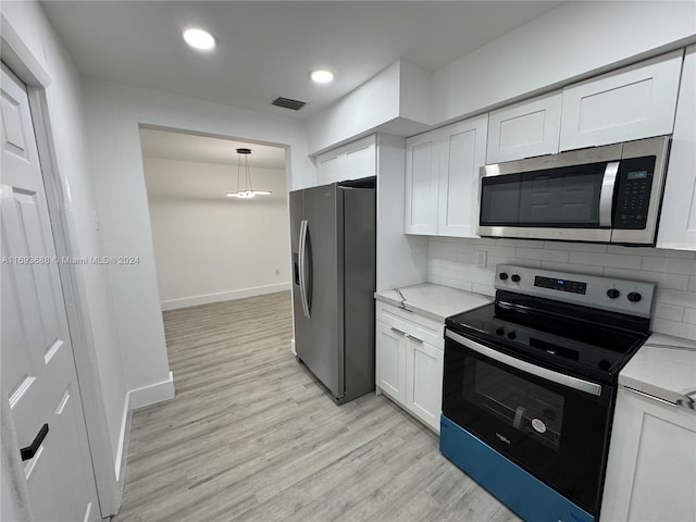 kitchen featuring decorative backsplash, appliances with stainless steel finishes, light hardwood / wood-style flooring, and white cabinetry