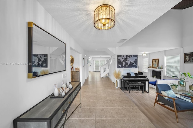 hallway with a textured ceiling and light hardwood / wood-style floors