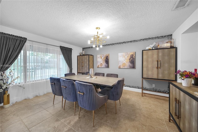 dining space featuring light tile patterned floors, a textured ceiling, and an inviting chandelier