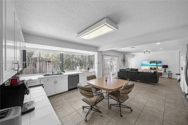 dining space featuring a textured ceiling, light tile patterned flooring, and sink