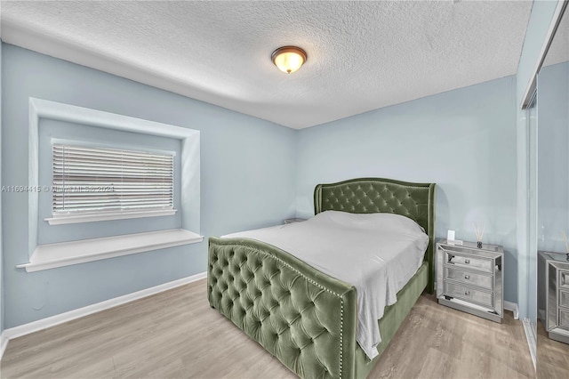 bedroom with a textured ceiling and hardwood / wood-style flooring