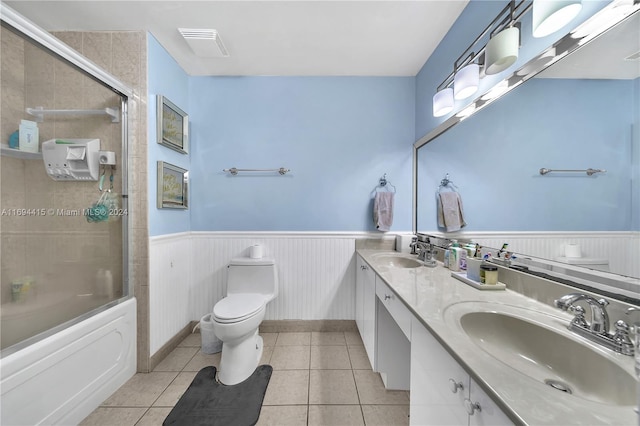 full bathroom featuring tile patterned flooring, vanity, combined bath / shower with glass door, and toilet