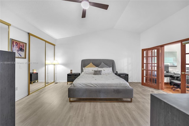 bedroom featuring light wood-type flooring, a closet, vaulted ceiling, and ceiling fan