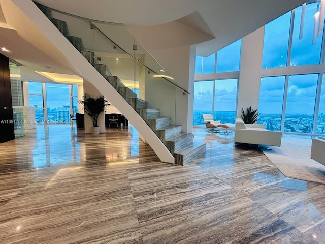 staircase featuring a water view and a towering ceiling