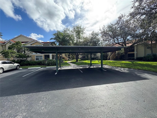 view of vehicle parking with a carport and a lawn