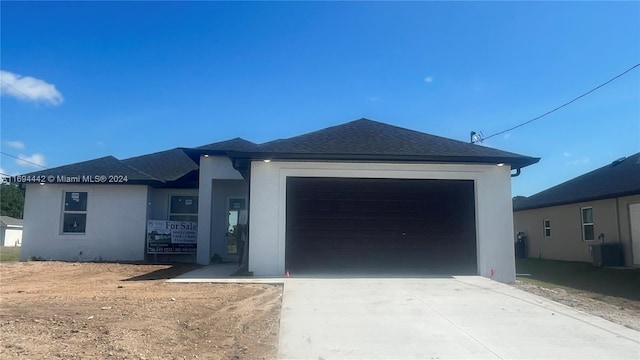 view of front of house featuring central AC unit and a garage