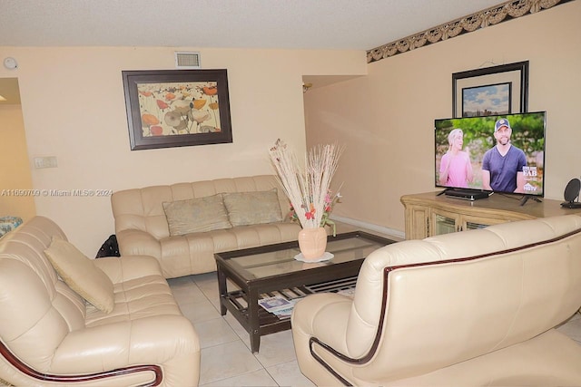 tiled living room featuring a textured ceiling