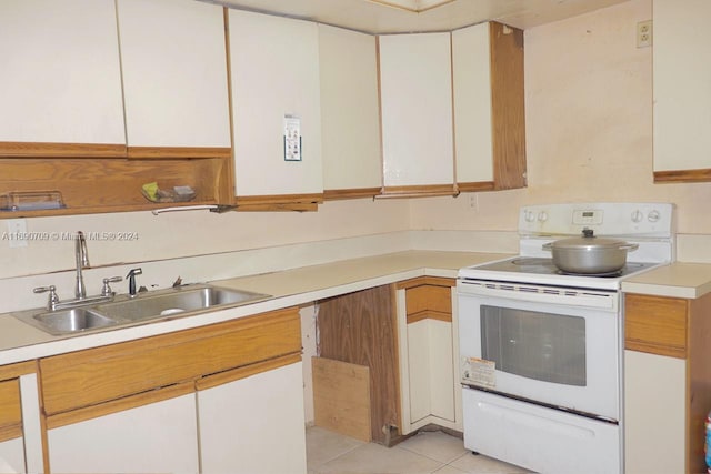 kitchen featuring white cabinets, light tile patterned flooring, white electric stove, and sink