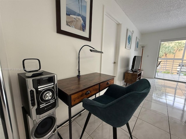 interior space featuring a textured ceiling, light tile patterned floors, and stacked washer / drying machine