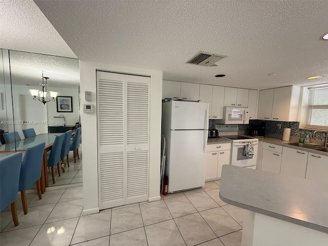 kitchen featuring pendant lighting, white cabinetry, white appliances, and light tile patterned floors