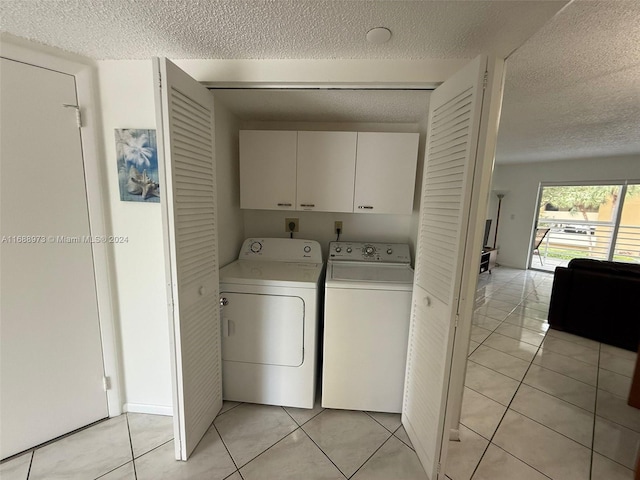 laundry area with cabinets, independent washer and dryer, a textured ceiling, and light tile patterned floors