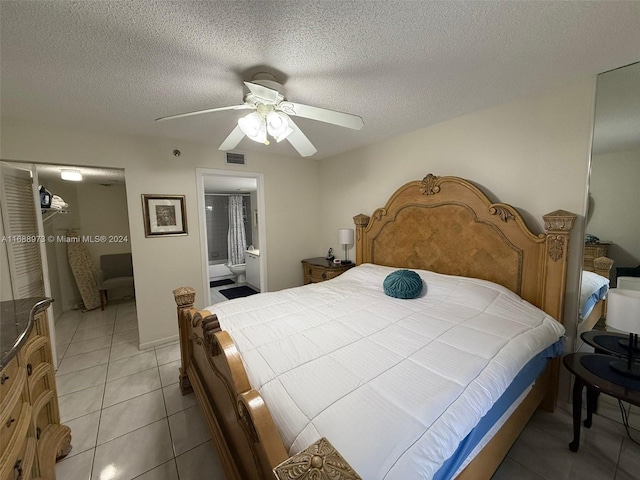 tiled bedroom with a textured ceiling, ensuite bathroom, and ceiling fan