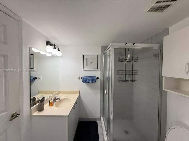 bathroom featuring tile patterned flooring, vanity, and walk in shower