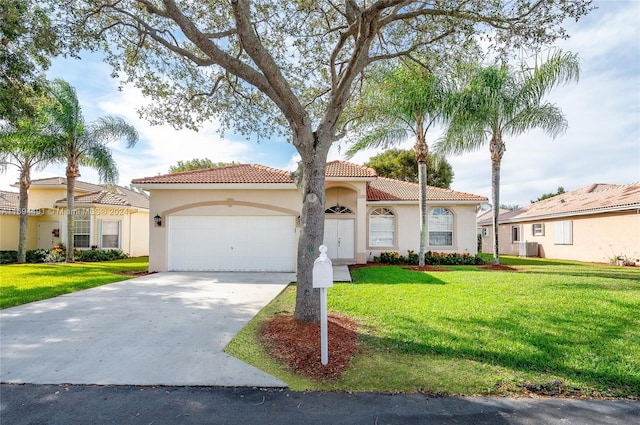 mediterranean / spanish home with a garage and a front lawn