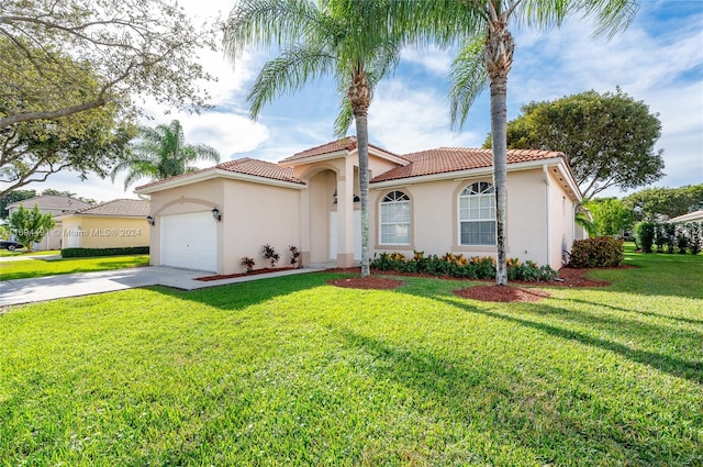 mediterranean / spanish house with a garage and a front lawn