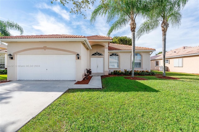 mediterranean / spanish-style home with a garage and a front lawn