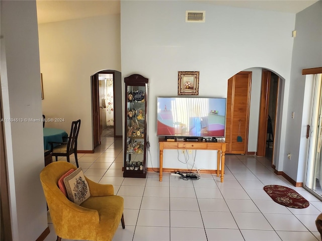 living room with light tile patterned flooring and high vaulted ceiling