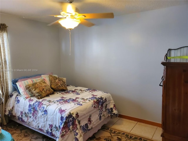 tiled bedroom featuring ceiling fan